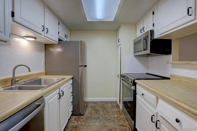 a kitchen with stainless steel appliances granite countertop a sink a stove and a refrigerator