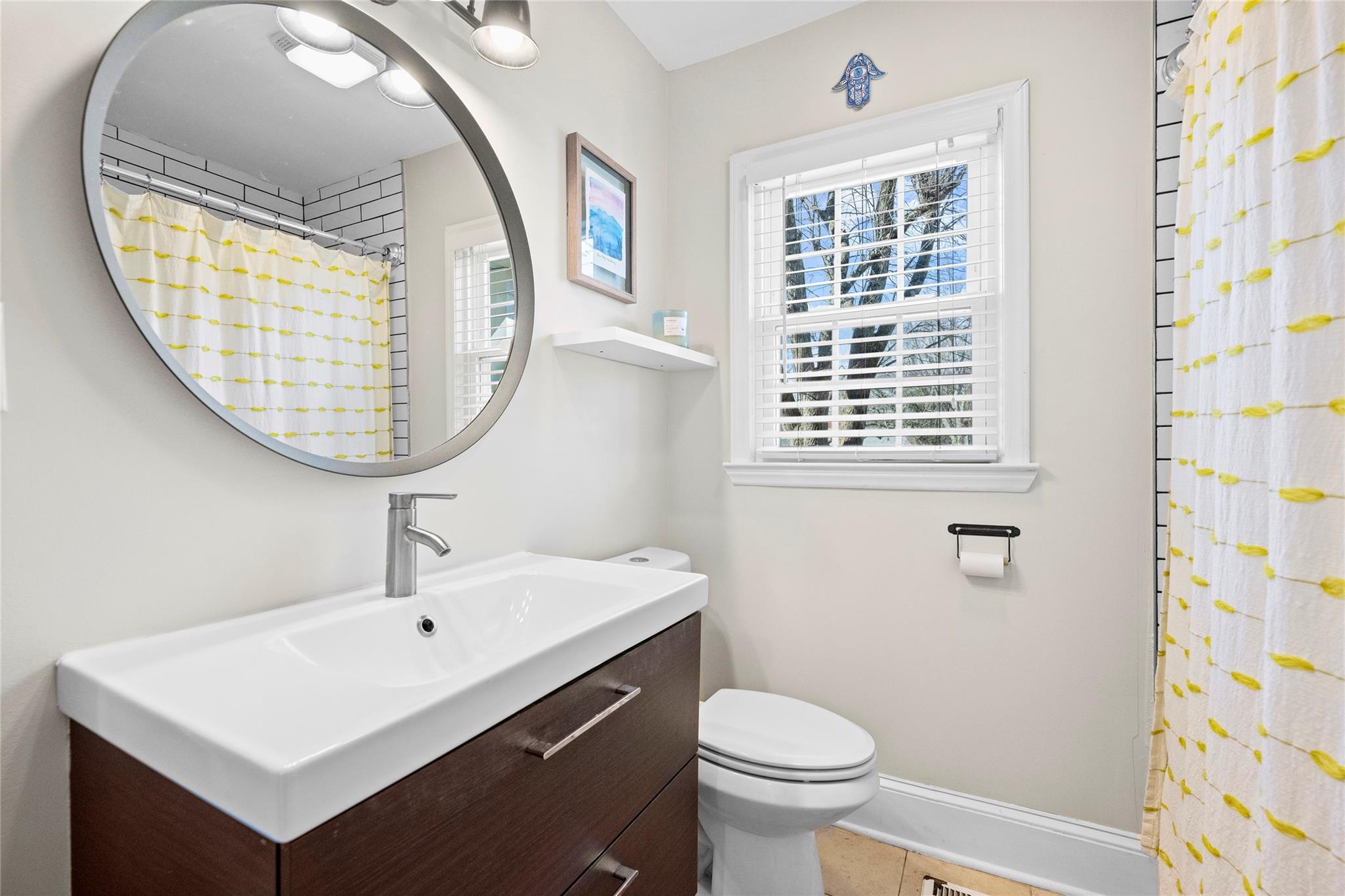1114 Norland Road Charlotte, NC 28205 - Photo 23 of 36 a bathroom with a sink a mirror a toilet and a window