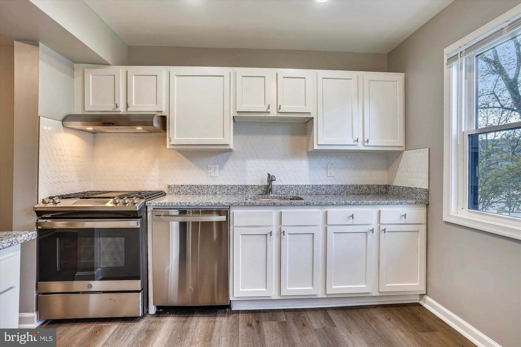 9202 Sprucewood Road Burke, VA 22015 - Photo 6 of 21 a kitchen with granite countertop white cabinets and stainless steel appliances