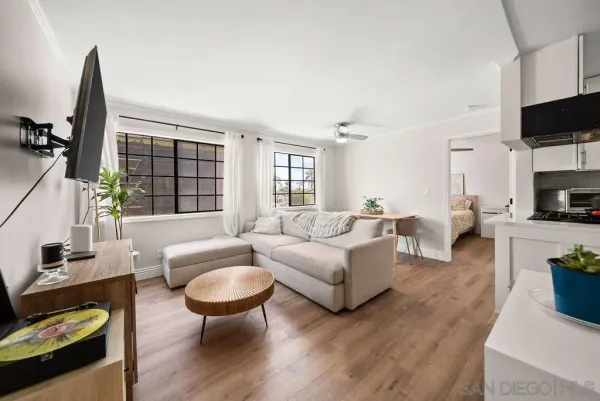 a living room with furniture a flat screen tv and a large window