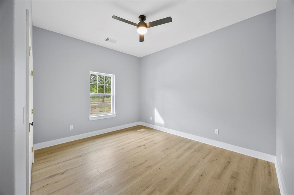 121 Brazier Road Ennis, TX 75119 - Photo 18 of 31 an empty room with wooden floor and ceiling fan