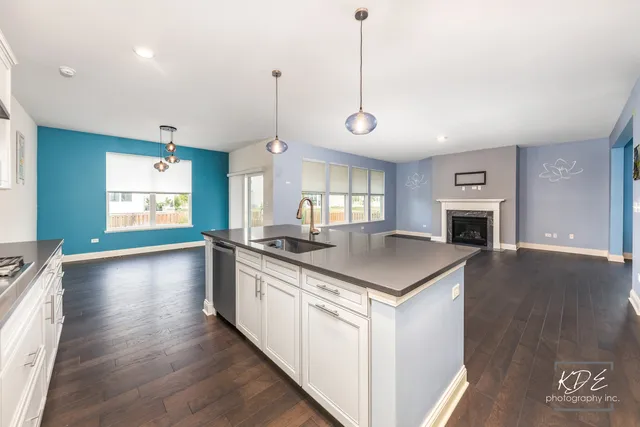 a kitchen with stove and wooden floor