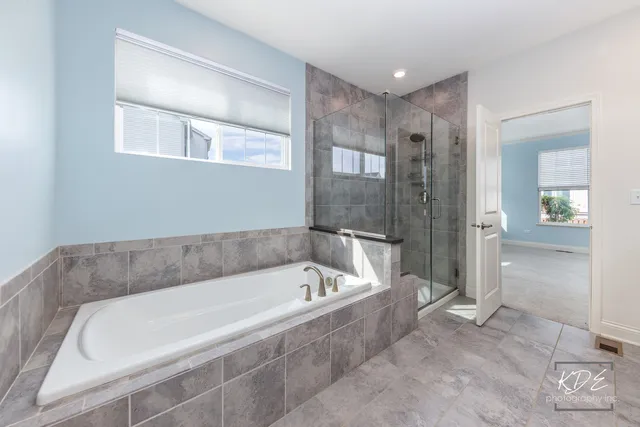 a spacious bathroom with a bathtub and shower