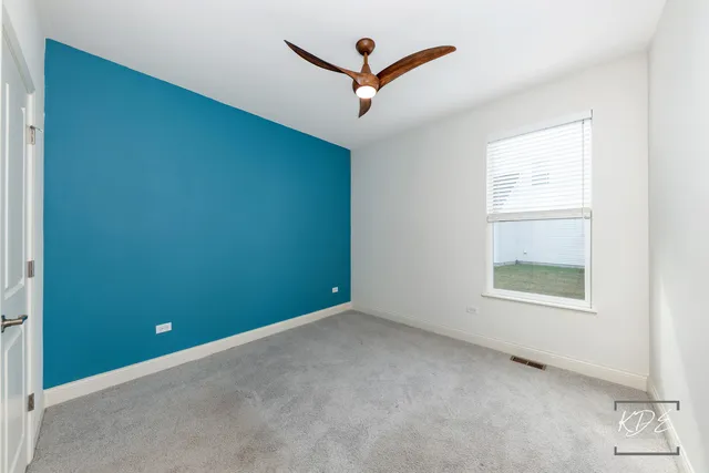 an empty room with a ceiling fan and a window