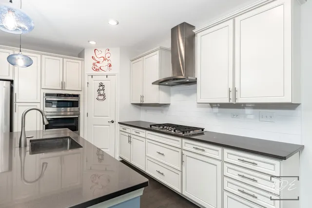 a kitchen with granite countertop a sink stainless steel appliances and cabinets