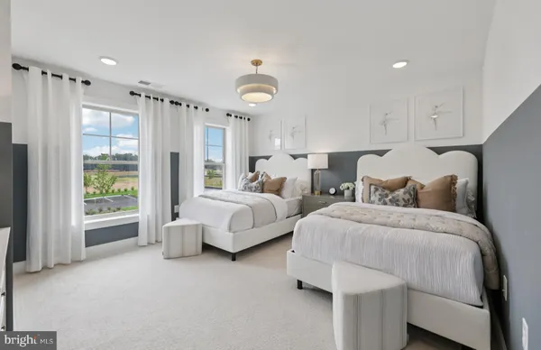 a bedroom with two beds and painting on the wall