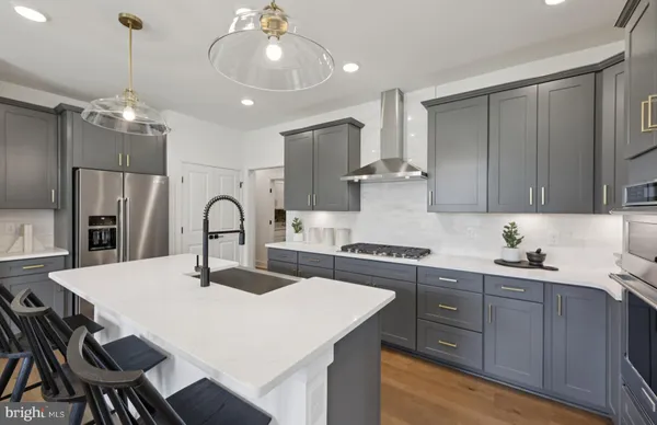 a kitchen with stainless steel appliances a table chairs in it and white cabinets