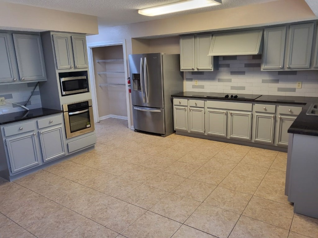 14810 Rancho Vista Drive Houston, TX 77083 - Photo 20 of 33 a kitchen with stainless steel appliances a refrigerator sink and cabinets