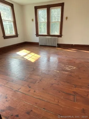 view of hall with wooden floor and chair