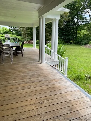 a view of house with yard and trees in the background