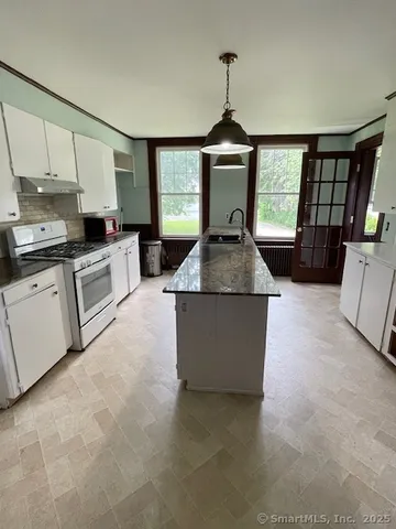 a kitchen with stainless steel appliances granite countertop a sink stove and a granite counter top