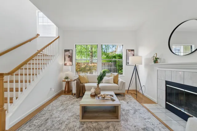 a living room with furniture a large window and a fireplace