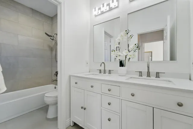 a bathroom with a granite countertop sink a toilet and a bathtub