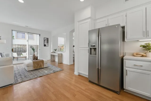 a large living room with stainless steel appliances granite countertop furniture and a large window