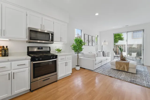 a kitchen with stainless steel appliances a stove a microwave a sink and cabinets