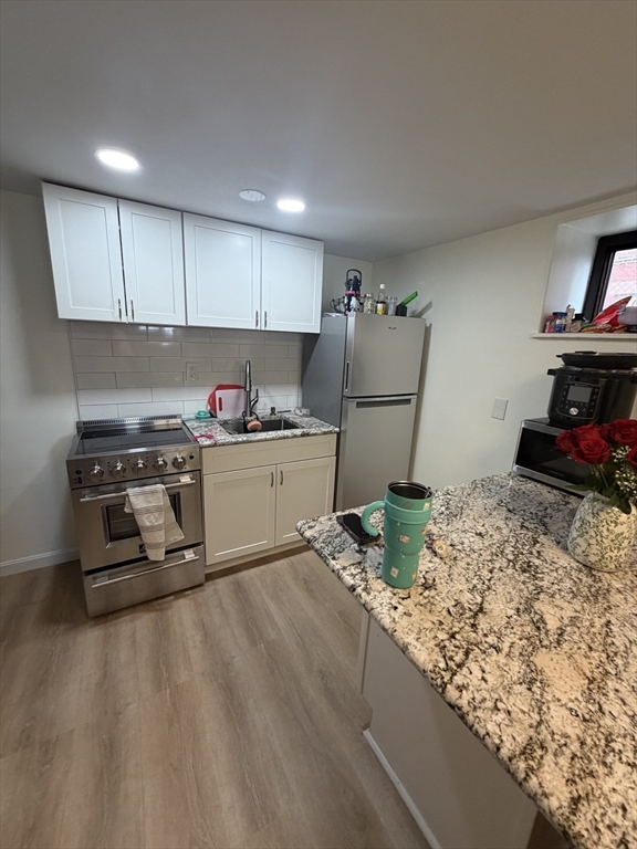 32 Reedsdale Street, Unit D Boston, MA 02134 - Photo 1 of 4 a kitchen with stainless steel appliances granite countertop a sink stove and refrigerator