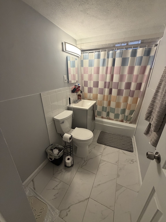 32 Reedsdale Street, Unit D Boston, MA 02134 - Photo 3 of 4 a bathroom with a toilet and a shower curtain