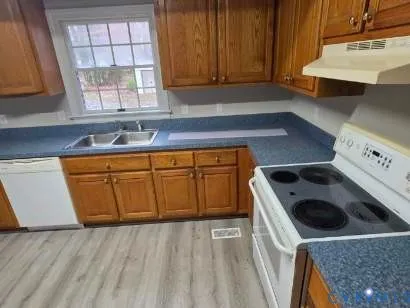 a kitchen with a sink a stove and cabinets