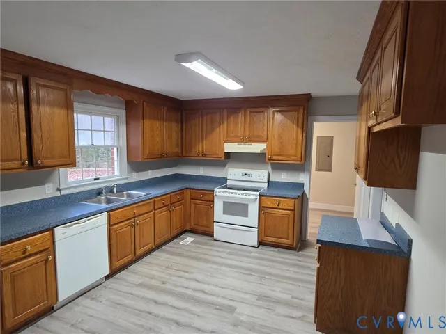 a kitchen with stainless steel appliances granite countertop wooden cabinets a sink and dishwasher with wooden floor
