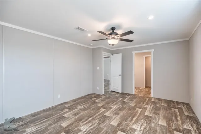 a view of a big room with wooden floor and a ceiling fan
