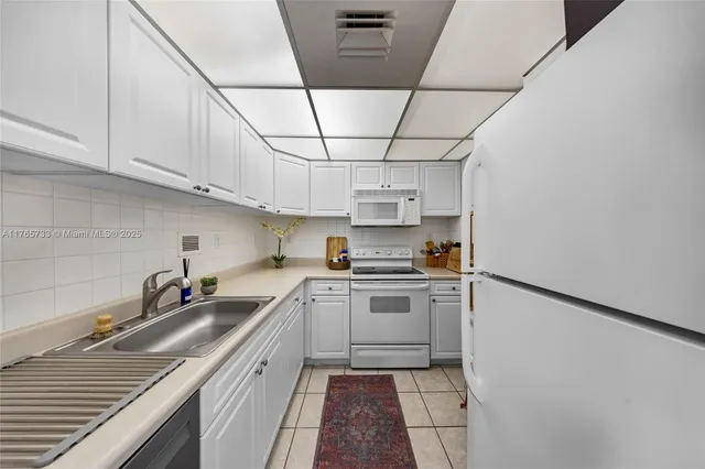 a kitchen with stainless steel appliances granite countertop white cabinets sink and granite counter tops