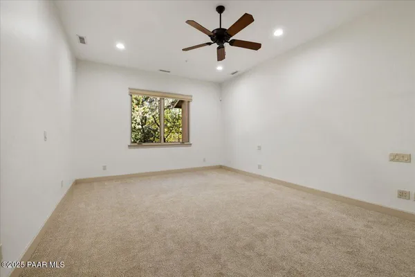 en empty room with window and a ceiling fan