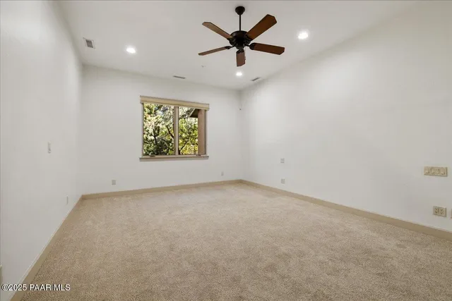 en empty room with window and a ceiling fan