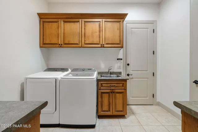 a utility room with sink dryer and washer