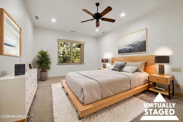 a bedroom with a large bed chandelier and a window