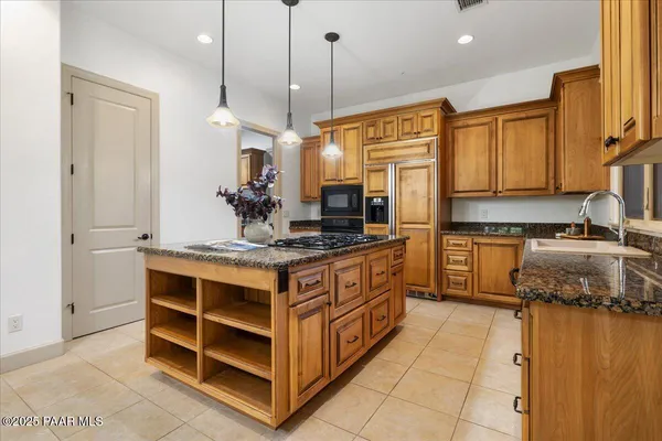 a kitchen with kitchen island granite countertop a sink counter top space and cabinets