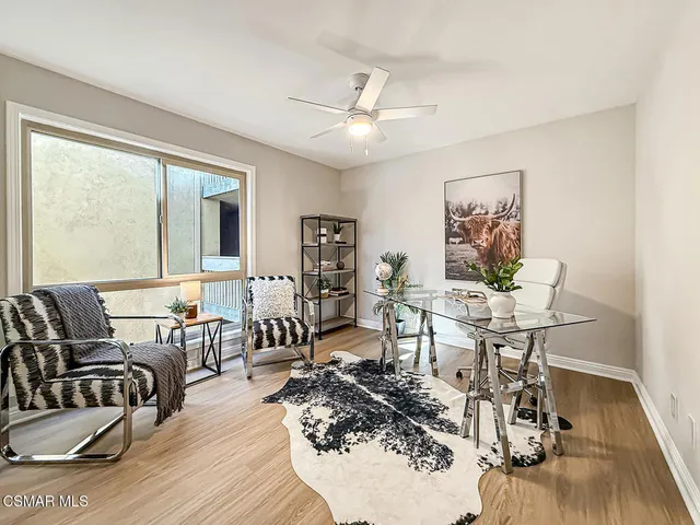 a living room with furniture large window and wooden floor
