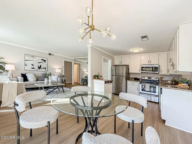 a kitchen with stainless steel appliances a refrigerator a stove a sink and white cabinets