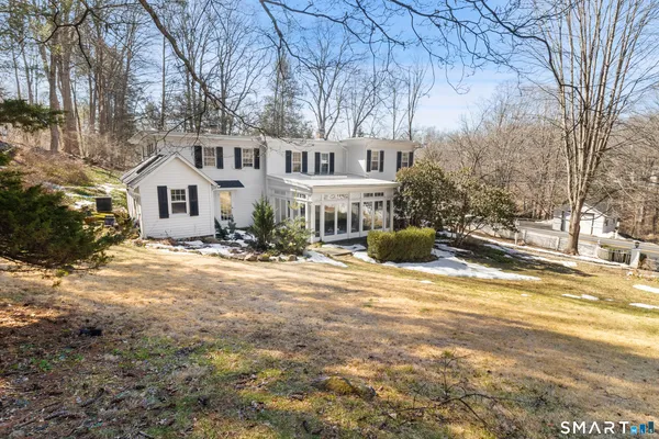 a front view of a house with a yard and large trees