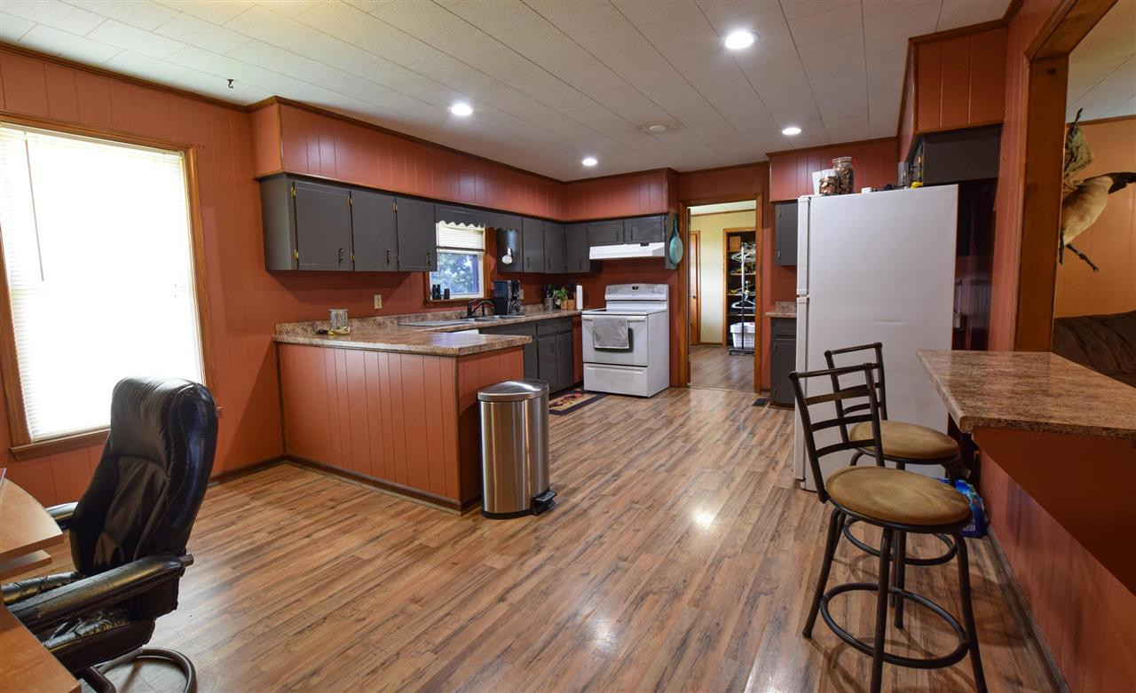 947 South Wolverine Road Troy, TN 38260 - Photo 13 of 20 a open kitchen with stainless steel appliances granite countertop a refrigerator a stove top oven a sink dishwasher and chairs with wooden floor