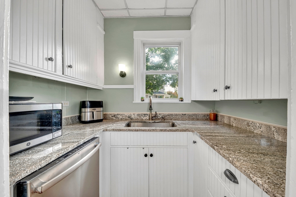 7 Melrose Street Amesbury, MA 01913 - Photo 14 of 34 a kitchen with granite countertop a sink stove and cabinets
