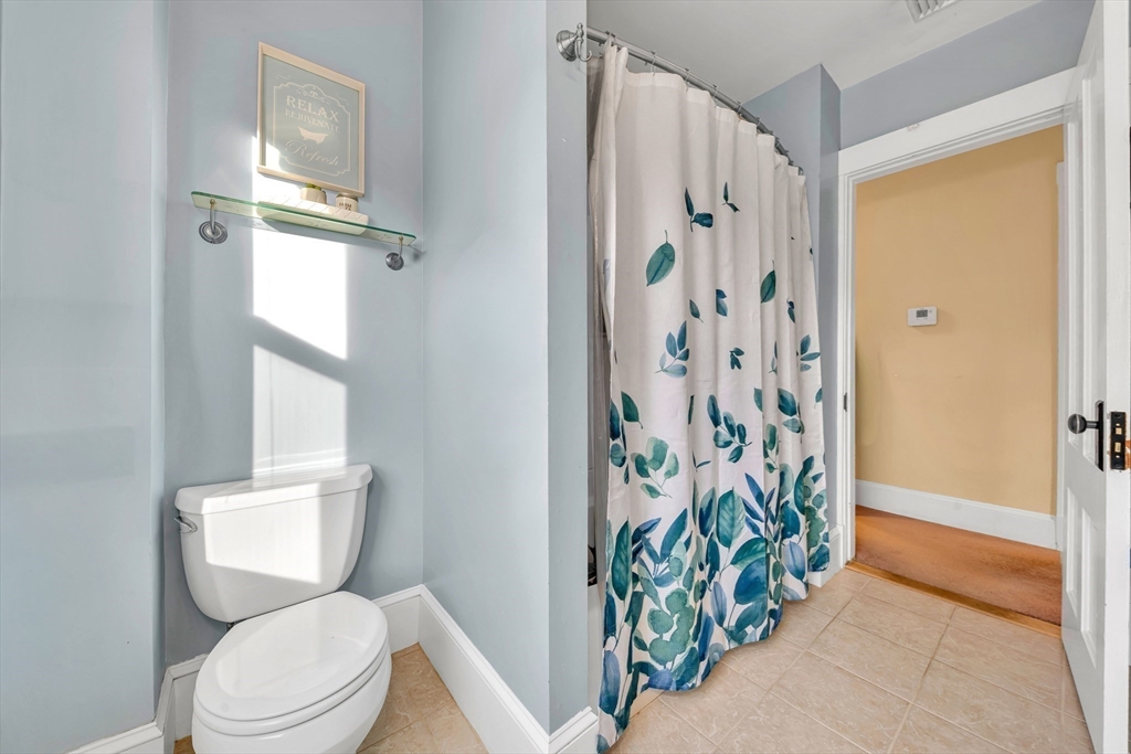 7 Melrose Street Amesbury, MA 01913 - Photo 25 of 34 a white toilet sitting next to a shower curtain