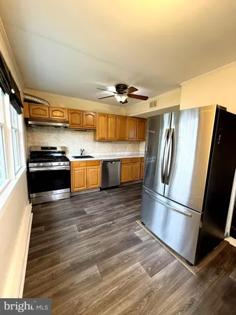 a kitchen with stainless steel appliances granite countertop a refrigerator and a stove