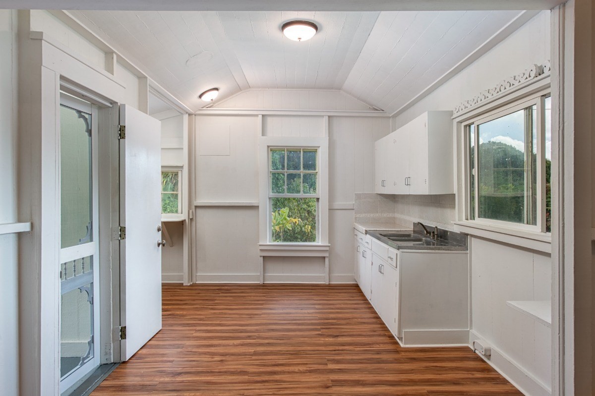 48-5314 Kukuihaele Road Honokaa, HI 96727 - Photo 7 of 24 a kitchen with stainless steel appliances granite countertop a refrigerator a sink dishwasher a stove and white countertops with wooden floor