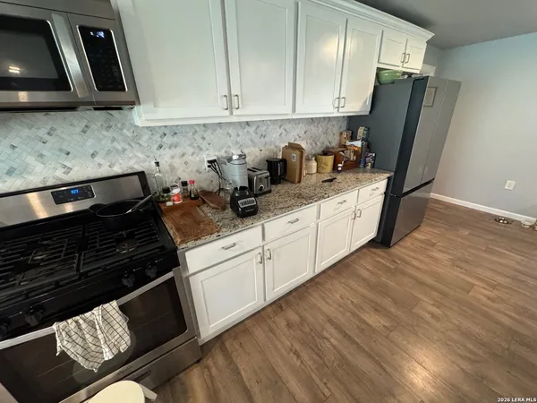 a kitchen with stainless steel appliances granite countertop a refrigerator stove and sink