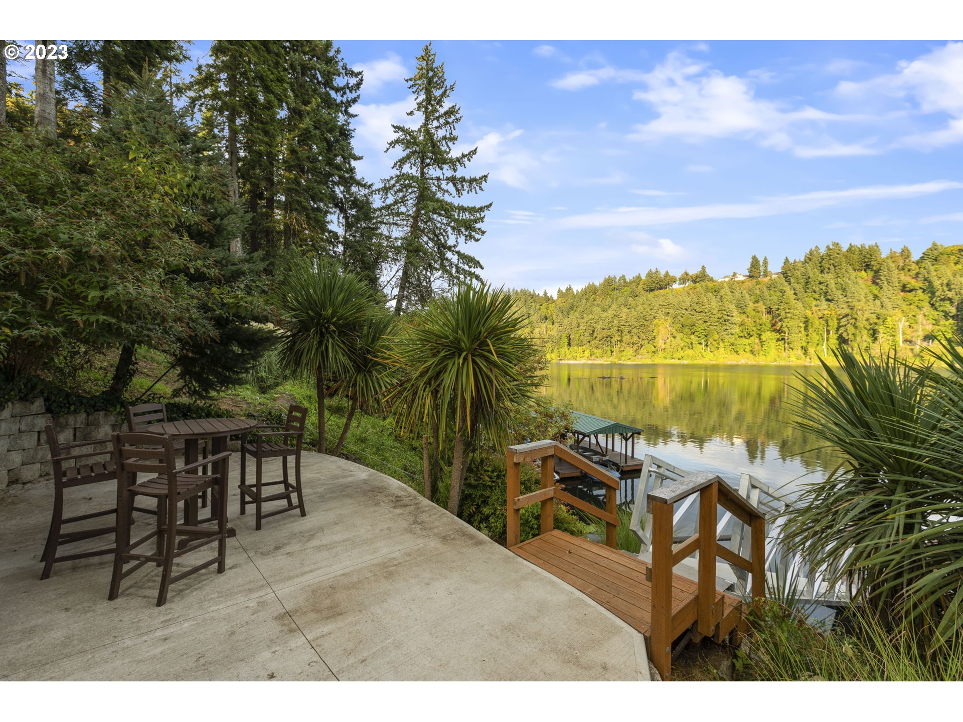 224 Southwest Forest Cove Road West Linn, OR 97068 - Photo 27 of 36 a view of a lake with a table and chairs