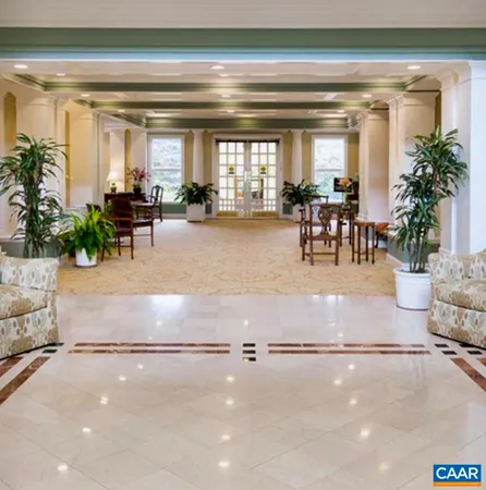 a living room with furniture and potted plants