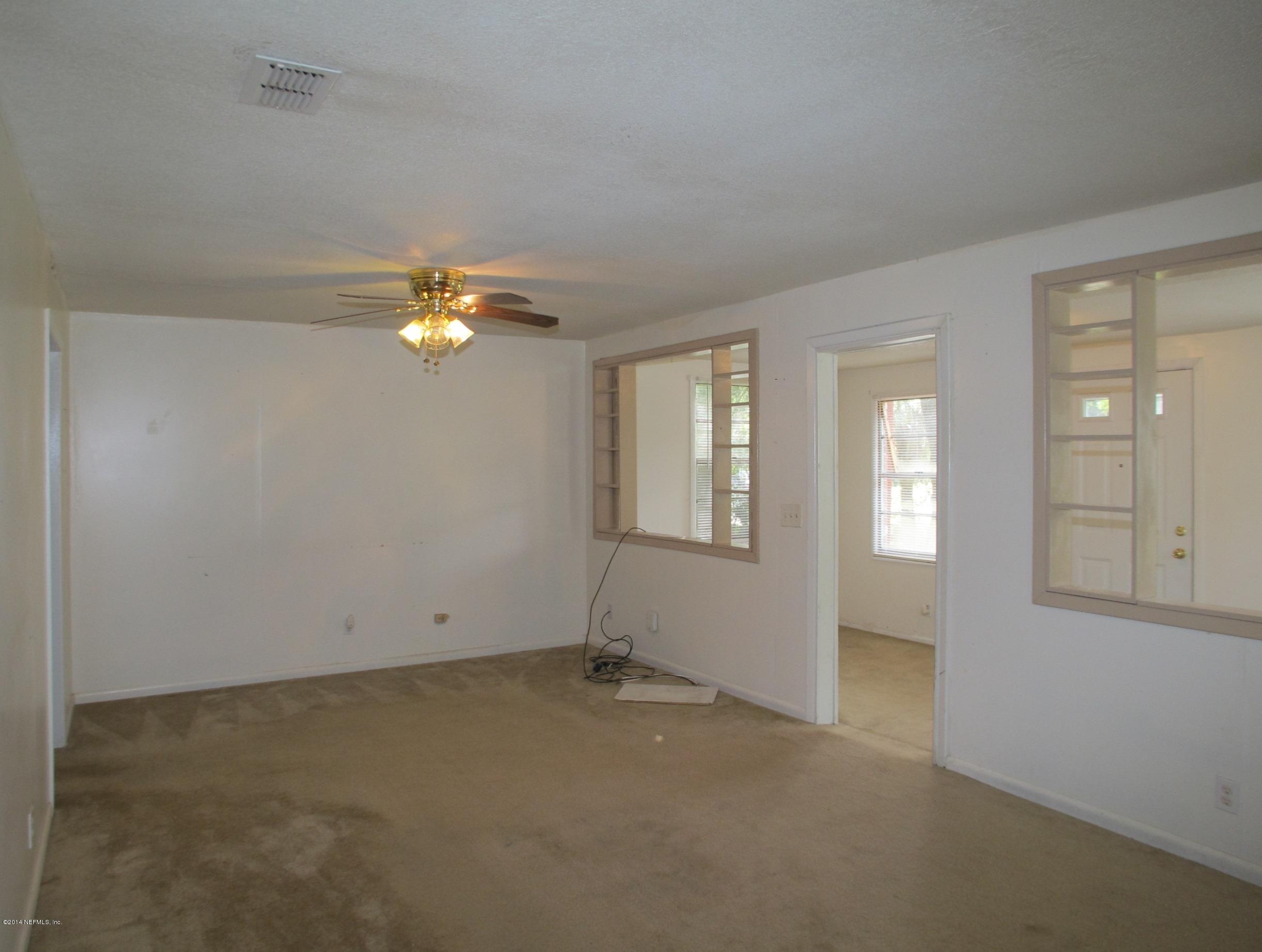 10593 Joes Road Jacksonville, FL 32221 - Photo 7 of 21 an empty room with chandelier fan and windows