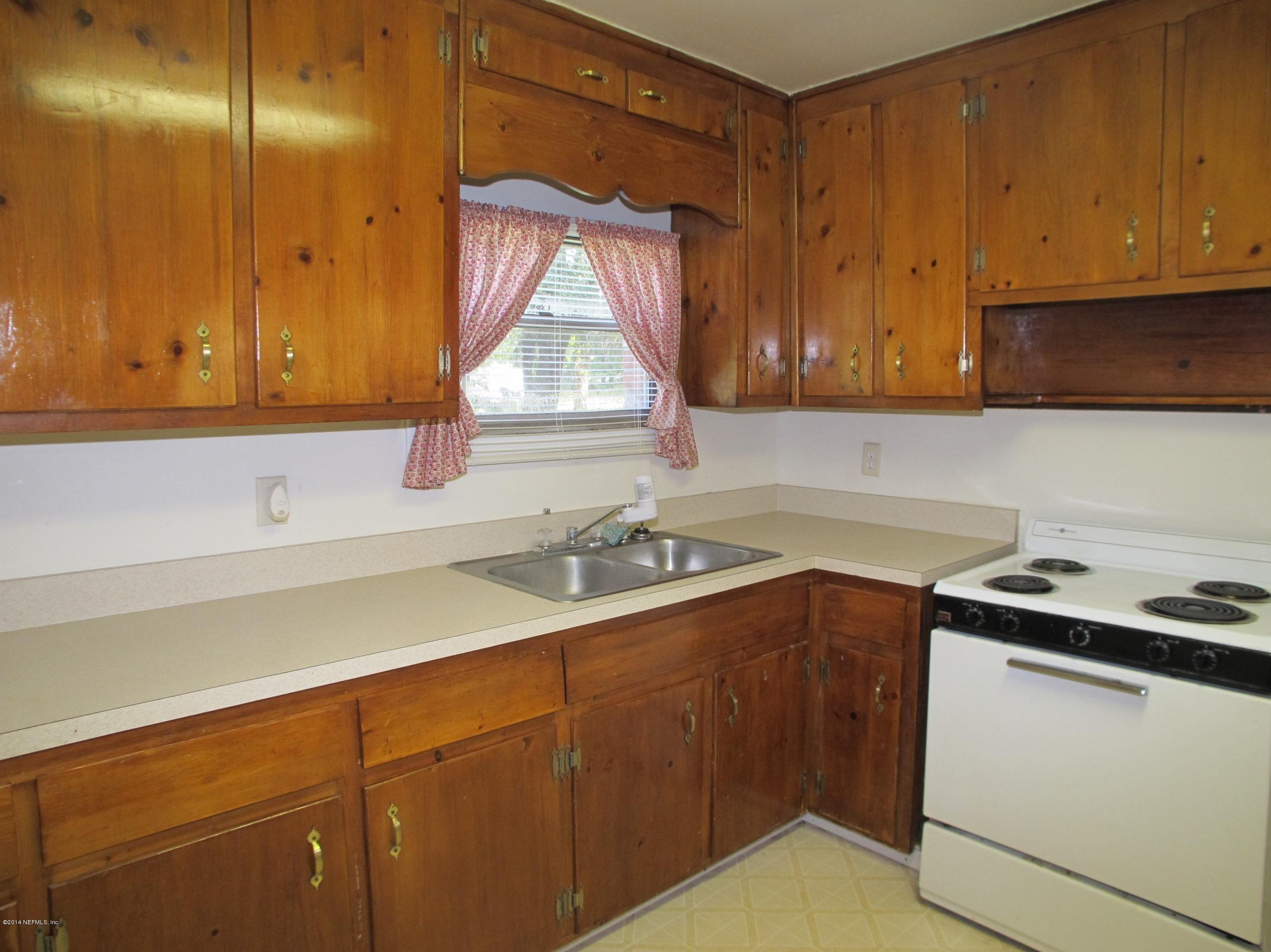 10593 Joes Road Jacksonville, FL 32221 - Photo 10 of 21 a kitchen with a sink cabinets and a stove top oven