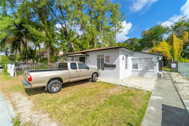 a white house covered with tall trees