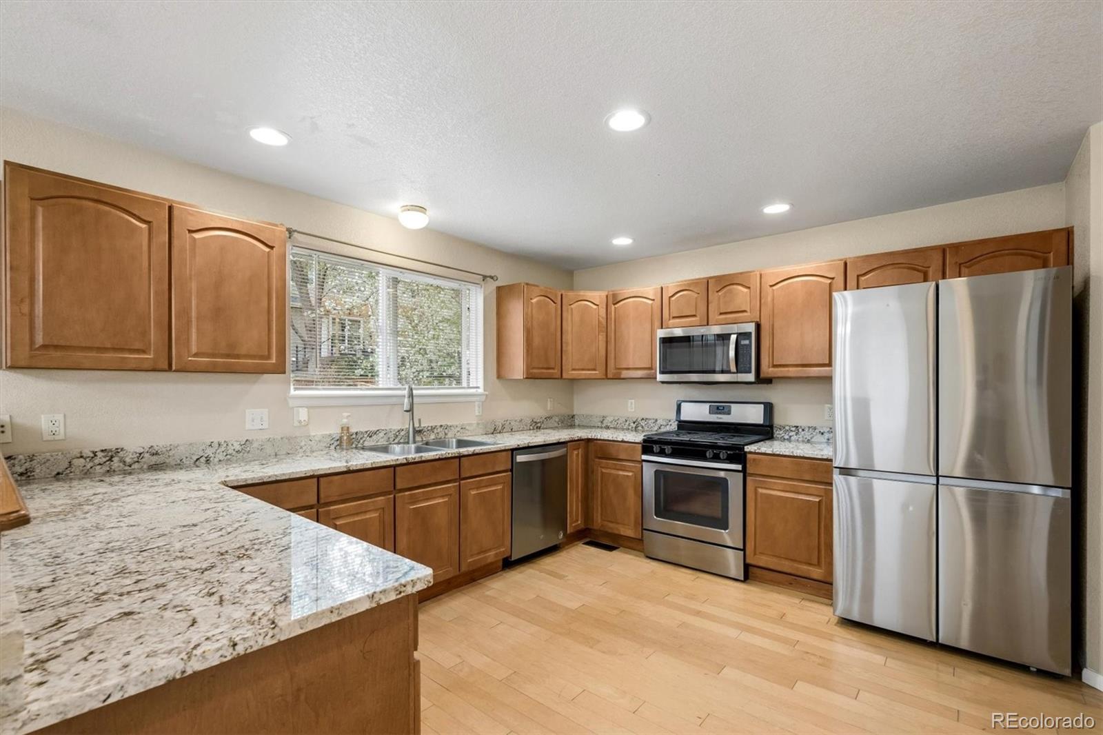 557 West Stellars Jay Drive Highlands Ranch, CO 80129 - Photo 11 of 41 a kitchen with granite countertop stainless steel appliances and wooden cabinets