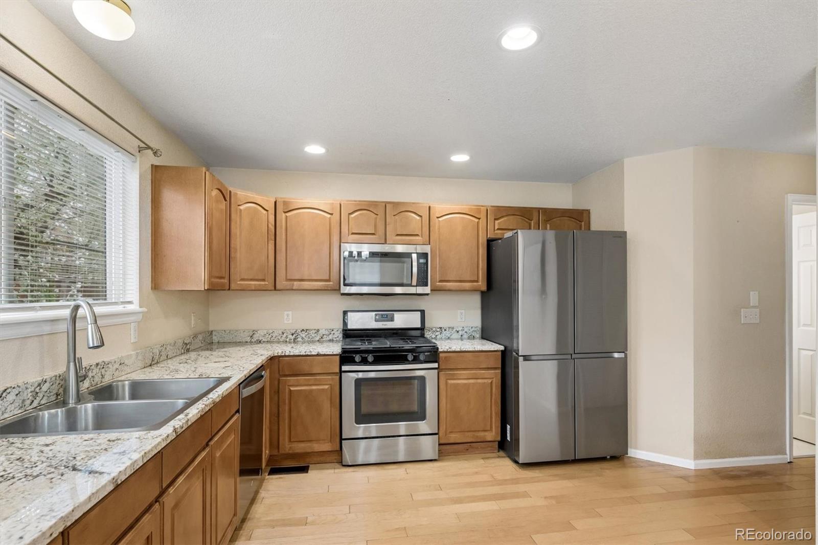 557 West Stellars Jay Drive Highlands Ranch, CO 80129 - Photo 12 of 41 a kitchen with a refrigerator sink and stove