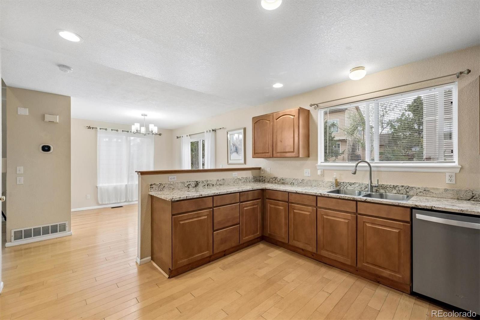 557 West Stellars Jay Drive Highlands Ranch, CO 80129 - Photo 14 of 41 a view of a kitchen with a sink and dishwasher wooden cabinets