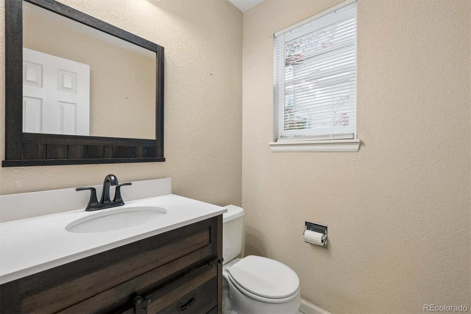 557 West Stellars Jay Drive Highlands Ranch, CO 80129 - Photo 15 of 41 a bathroom with a sink a mirror and a toilet