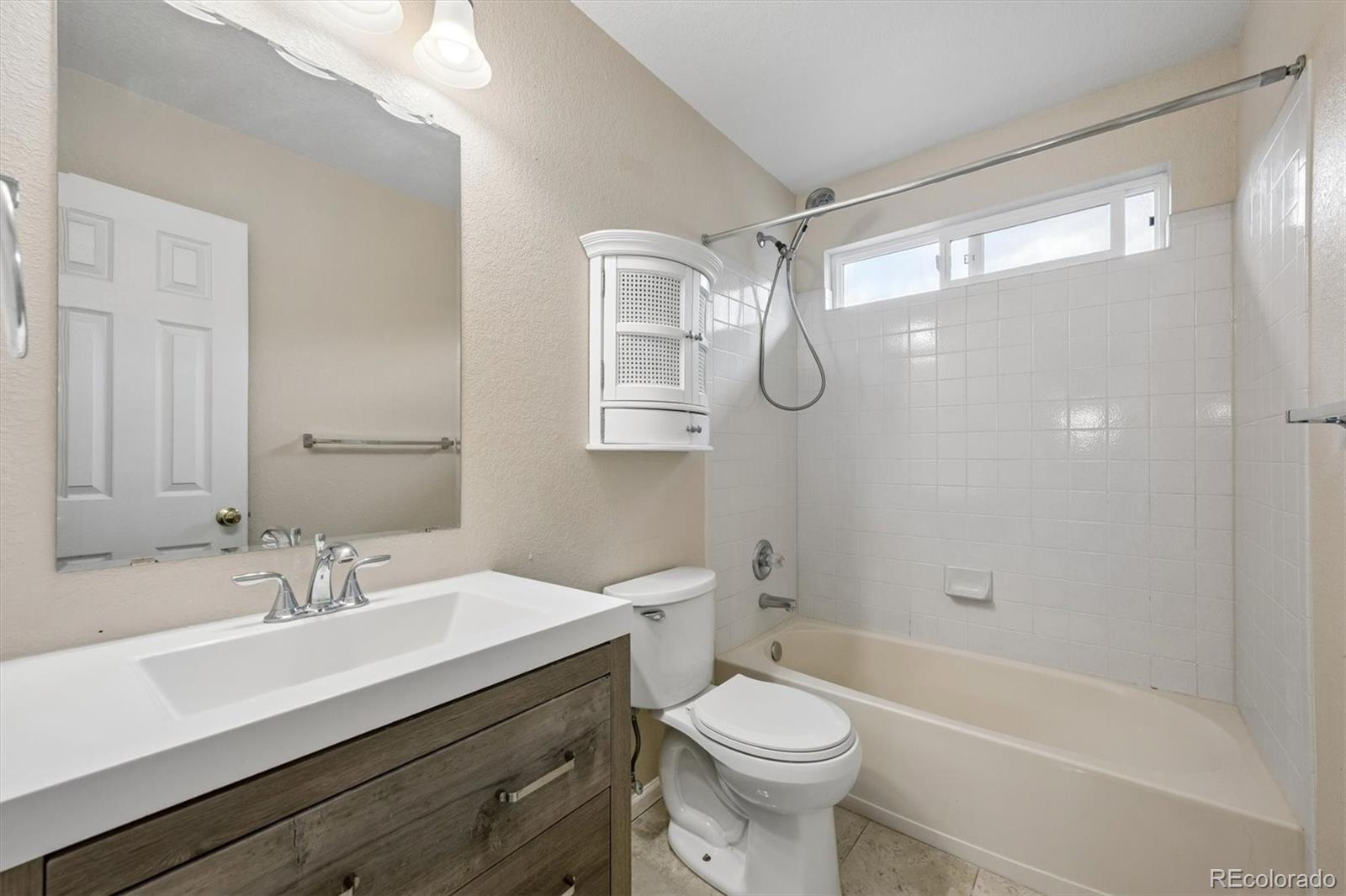 557 West Stellars Jay Drive Highlands Ranch, CO 80129 - Photo 25 of 41 a bathroom with a sink a toilet a mirror and a glass door shower