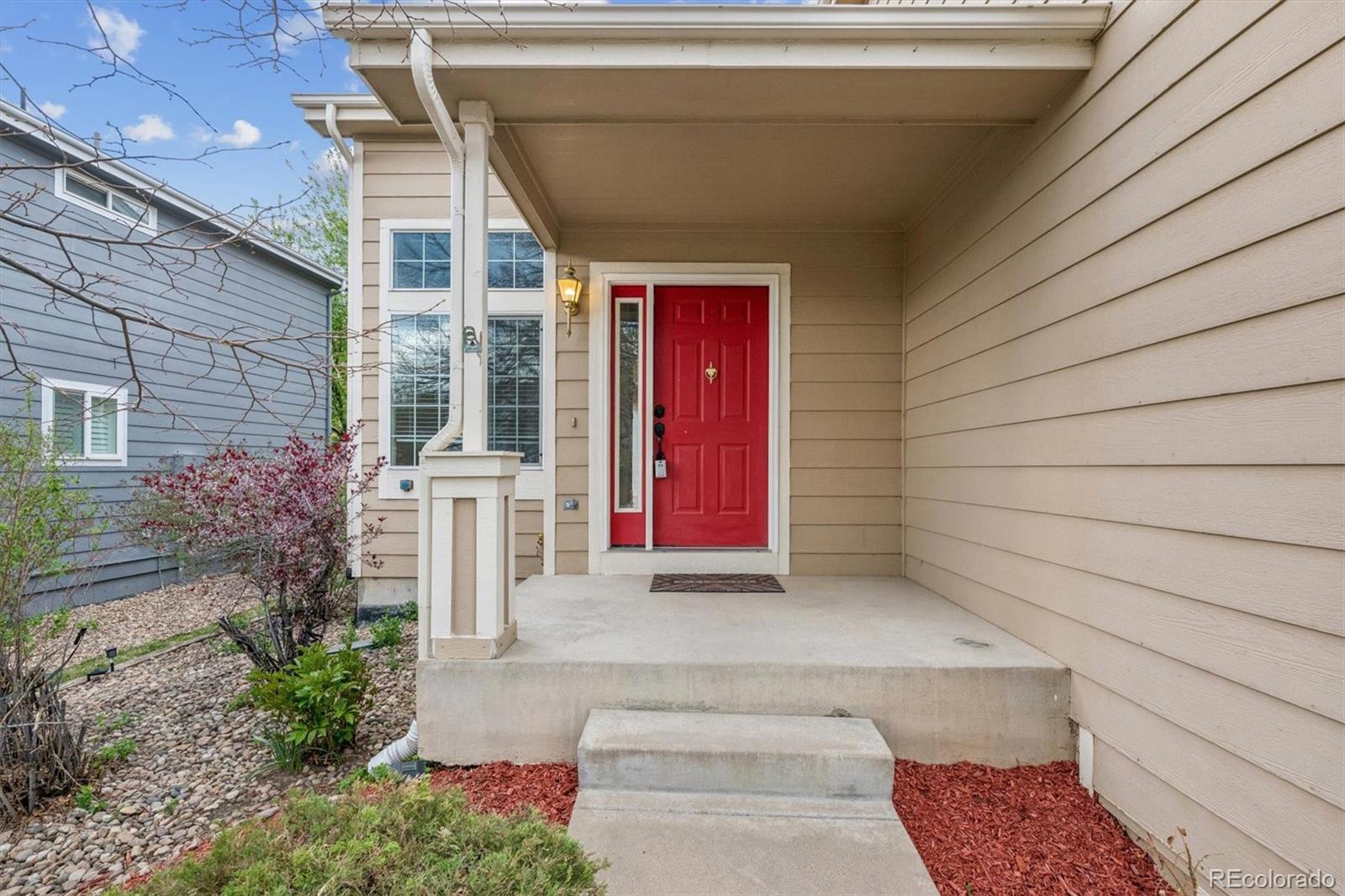 557 West Stellars Jay Drive Highlands Ranch, CO 80129 - Photo 3 of 41 a view of a house with red door and flower plants